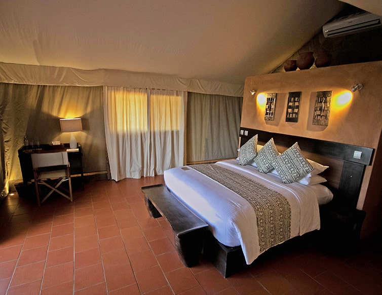 Image of the room from a side angle with the bed, pillows and desk