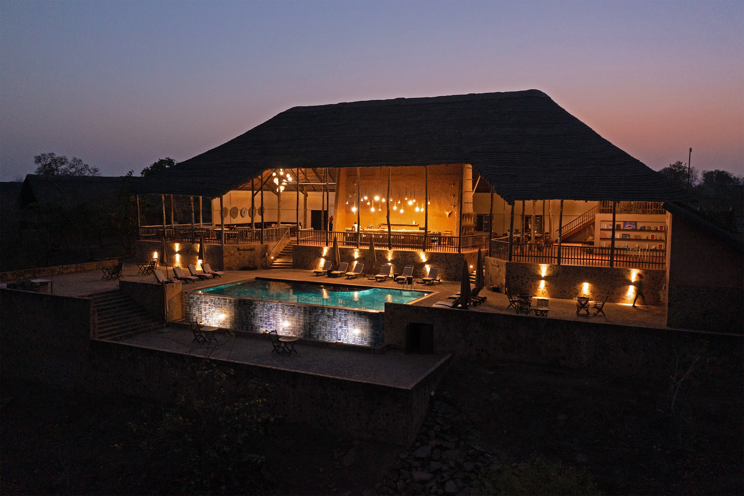 Image from a drone showing the vibrant colours of dusk at the back with a view of the infinity pool, dining area and bar at Zaina Lodge, Mole National Park, Ghana